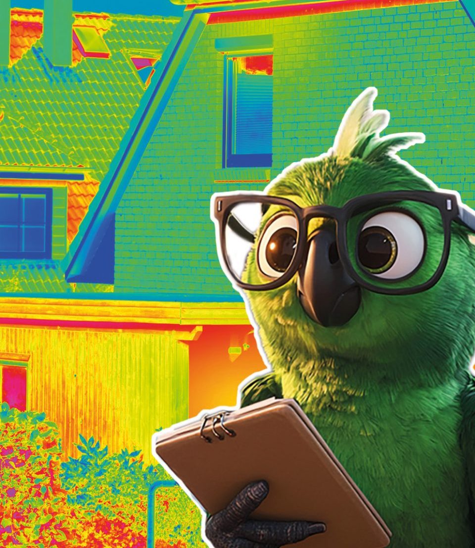 Röni das Maskottchen des KlimaVeedels der RheinEnergie steht mit einem Klemmbrett vor einem Wärmebild eines Einfamilienhauses